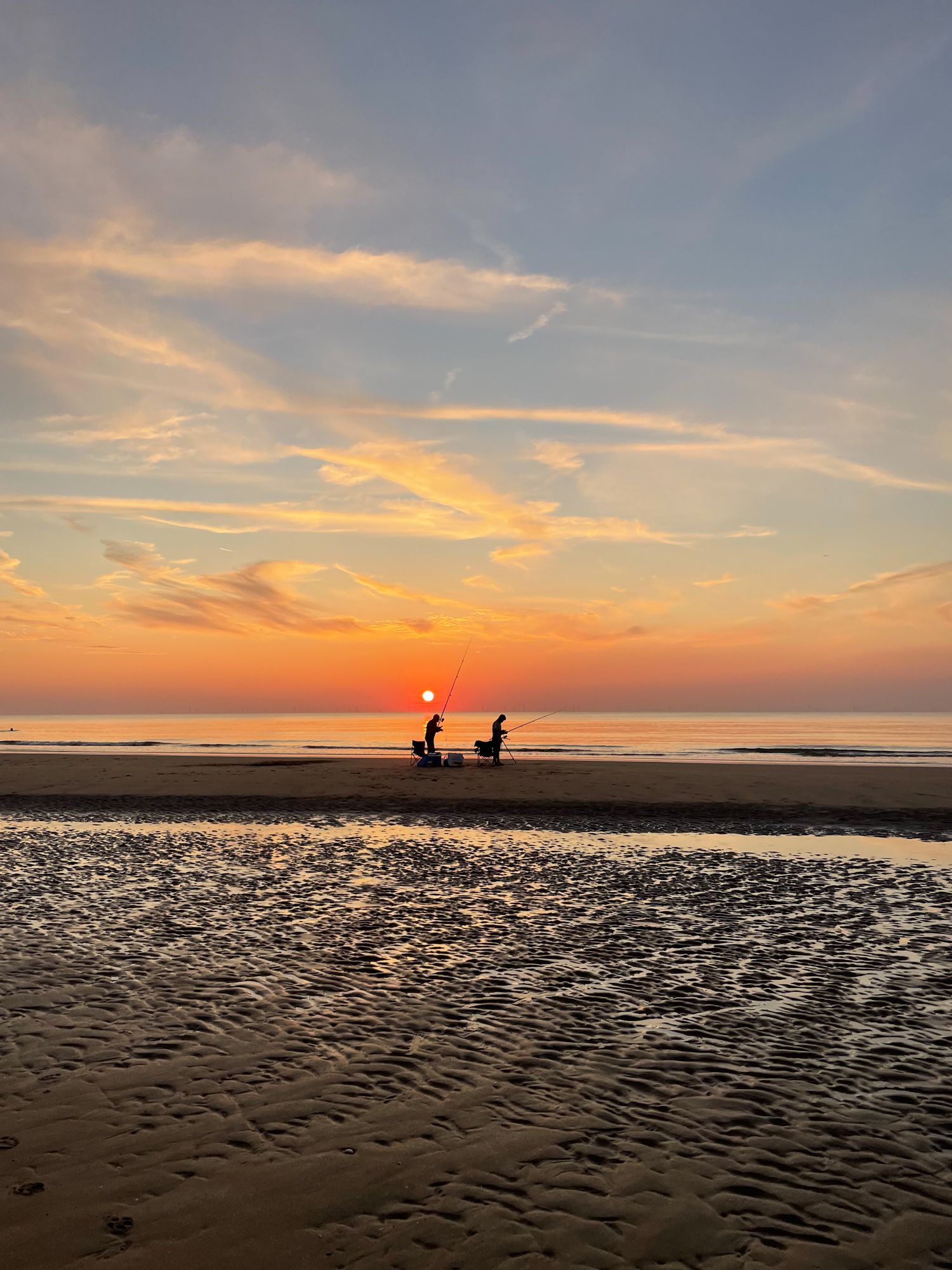 Fishermans on a beach in sunset